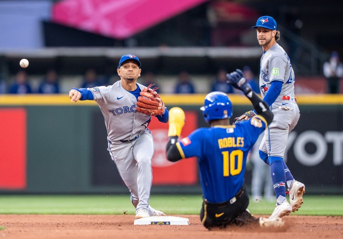 3 de julho de 2026; Seattle, Washington, EUA; O shortstop do Toronto Blue Jays, Andres Gimenez (0), à esquerda, faz uma jogada dupla depois de forçar a saída do defensor central do Seattle Mariners, Victor Robles (10), na segunda base durante a terceira entrada no T-Mobile Park. Crédito obrigatório: Stephen Brashear-Imagn Images