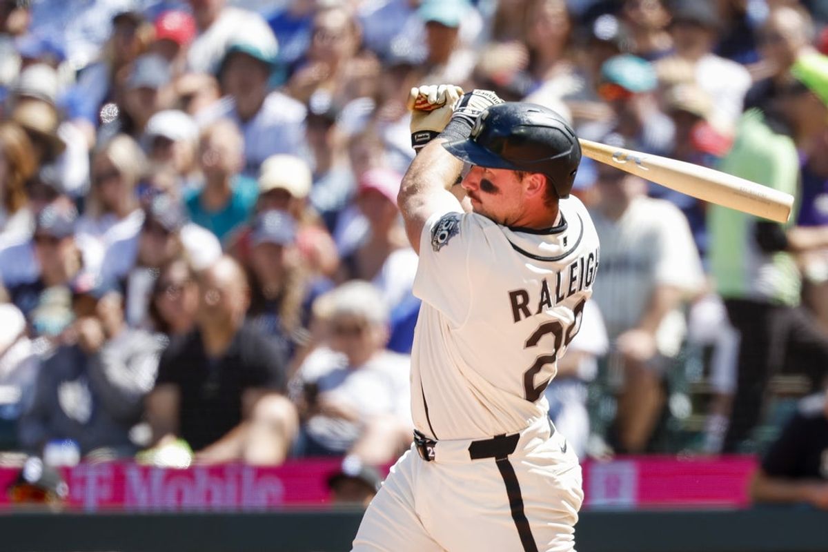 5 de julho de 2026; Seattle, Washington, EUA; O rebatedor designado do Seattle Mariners, Cal Raleigh (29), acerta uma mosca de sacrifício RBI contra o Toronto Blue Jays durante a terceira entrada no T-Mobile Park. Crédito obrigatório: Joe Nicholson-Imagn Images