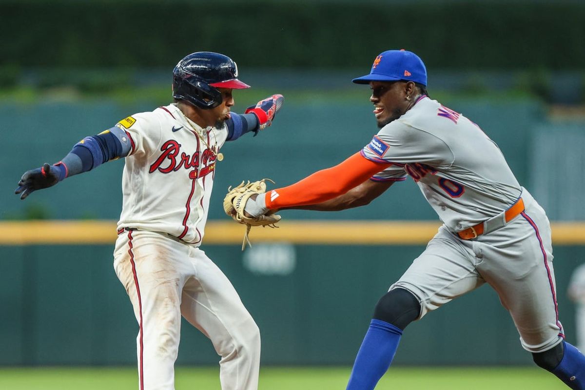 Jul 6, 2026; Cumberland, Georgia, USA; Atlanta Braves second baseman Ozzie Albies (1) attempts to jump out of the way to avoid an out against New York Mets shortstop Ronny Mauricio (0) during the fifth inning at Truist Park. Mandatory Credit: Jordan Godfree-Imagn Images