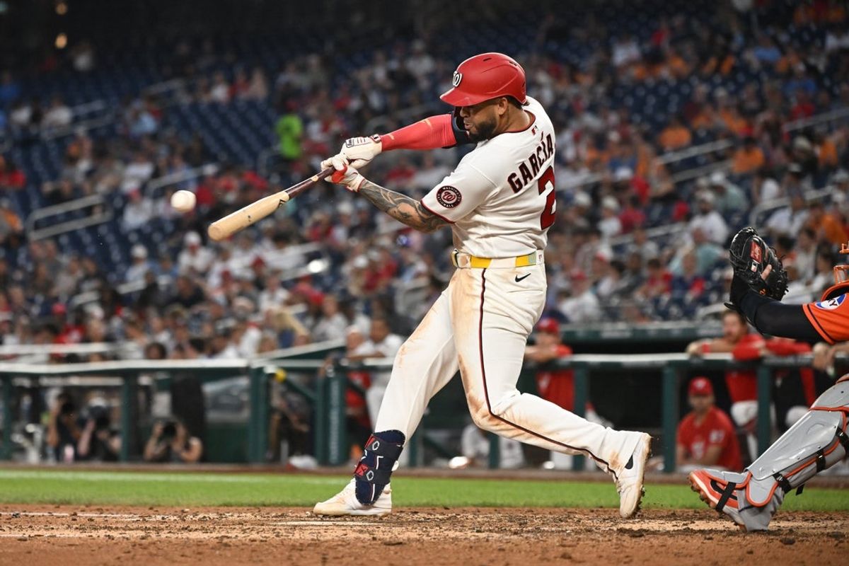 Jul 8, 2026; Washington, District of Columbia, USA; Washington Nationals first baseman Luis Garcia Jr. (2) hits the ball into play against the Houston Astros during the sixth inning at Nationals Park. Mandatory Credit: Rafael Suanes-Imagn Images