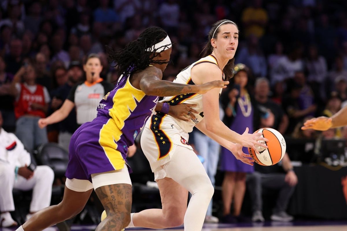 Jul 8, 2026; Los Angeles, California, USA;  Indiana Fever guard Caitlin Clark (22) looks to pass as Los Angeles Sparks guard Erica Wheeler (17) defends during the first quarter at Crypto.com Arena. Mandatory Credit: Kiyoshi Mio-Imagn Images