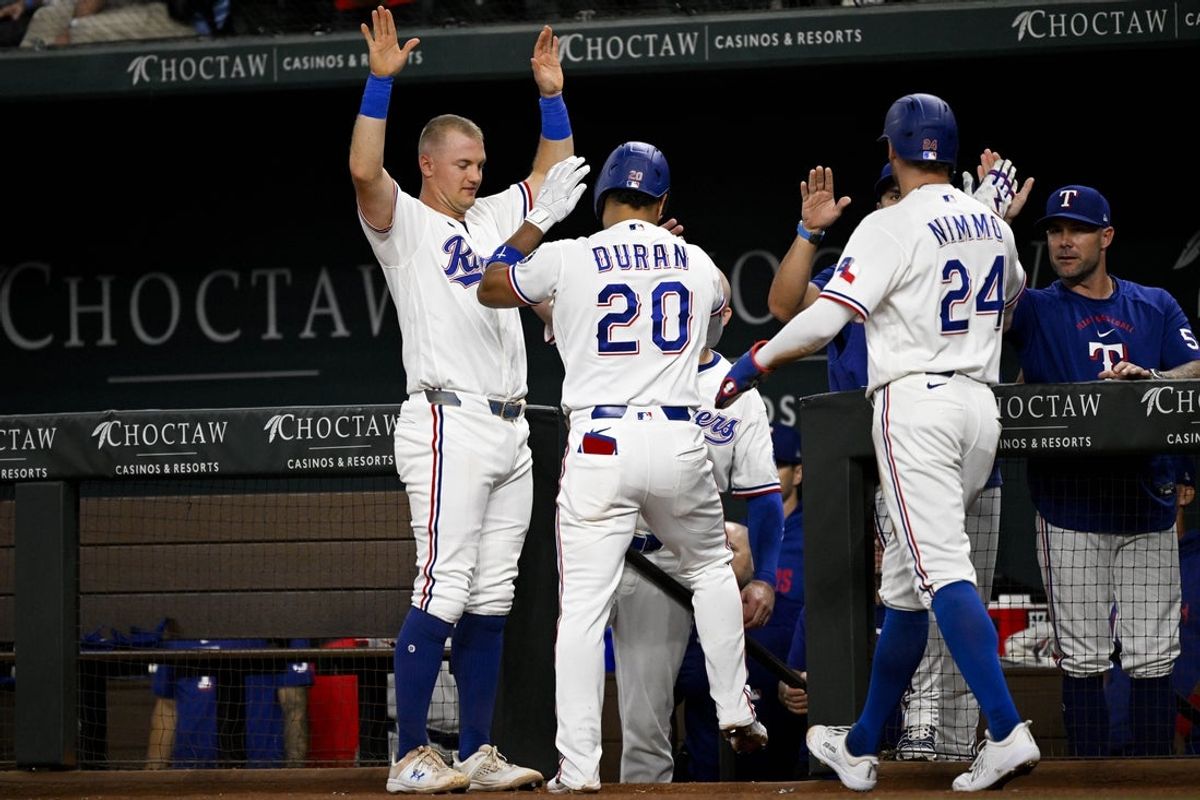 Jul 9, 2026; Arlington, Texas, USA; Texas Rangers shortstop Ezequiel Duran (20) and right fielder Brandon Nimmo (24) and third baseman Josh Jung (6) celebrate after Duran hits a two run home run against the Los Angeles Angels during the third inning at Globe Life Field. Mandatory Credit: Jerome Miron-Imagn Images