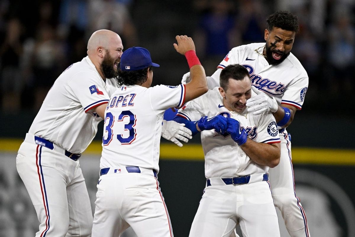 Jul 9, 2026; Arlington, Texas, USA; Texas Rangers designated hitter Wyatt Langford (36) and pinch hitter Nicky Lopez (33) and first baseman Jake Burger (21) and shortstop Ezequiel Duran (20) celebrate after Langford hits a game winning walk-off single against the Los Angeles Angels during the ninth inning at Globe Life Field. Mandatory Credit: Jerome Miron-Imagn Images