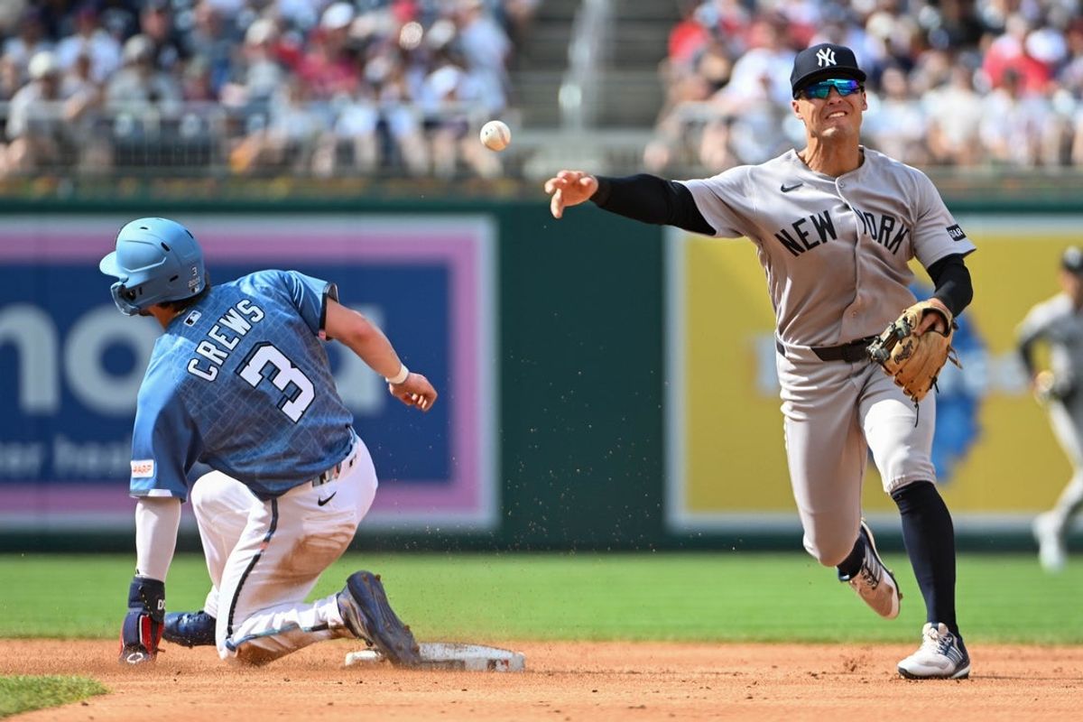 Jul 10, 2026; Washington, District of Columbia, USA; New York Yankees shortstop Anthony Volpe (11) completes a double play over Washington Nationals center fielder Dylan Crews (3) during the second inning at Nationals Park. Mandatory Credit: Brad Mills-Imagn Images