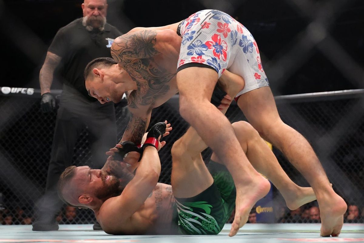 Jul 11, 2026; Las Vegas, Nevada, USA; Conor McGregor (red gloves) fights Max Holloway (blue gloves) in a welterweight bout during UFC 329 at T-Mobile Arena. Mandatory Credit: Mark J. Rebilas-Imagn Images