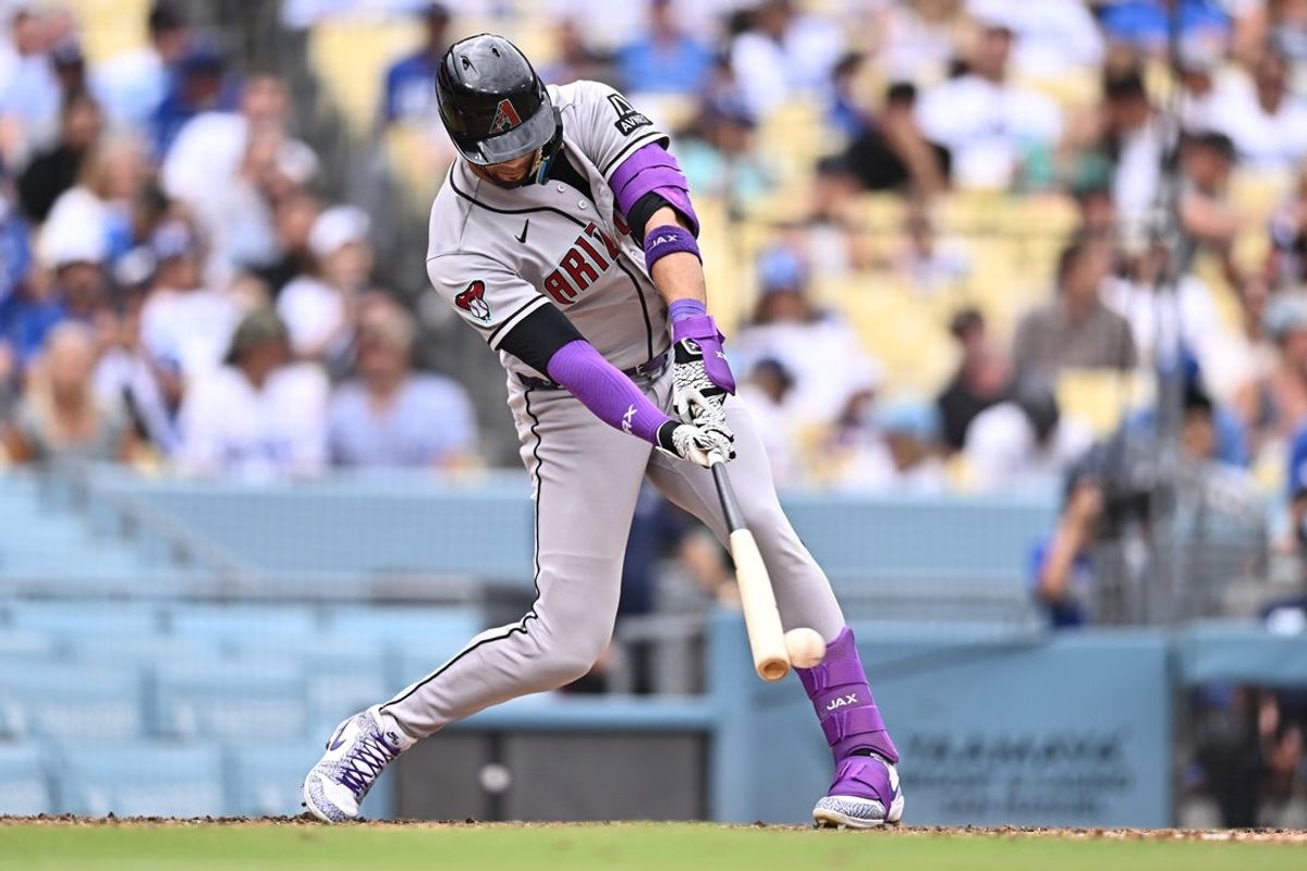 Jul 12, 2026; Los Angeles, California, USA; Arizona Diamondbacks left fielder Lourdes Gurriel Jr. (12) hits an RBI fielder's choice during the sixth inning against the Los Angeles Dodgers at Dodger Stadium. Mandatory Credit: William Liang-Imagn Images