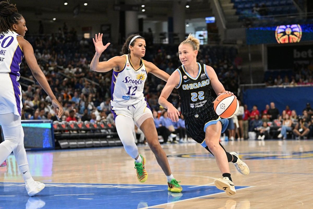 Jul 17, 2026; Chicago, Illinois, USA; Chicago Sky guard Courtney Vandersloot (22) drives the ball against Los Angeles Sparks guard-forward Rae Burrell (12) during the first half at Wintrust Arena. Mandatory Credit: Patrick Gorski-Imagn Images