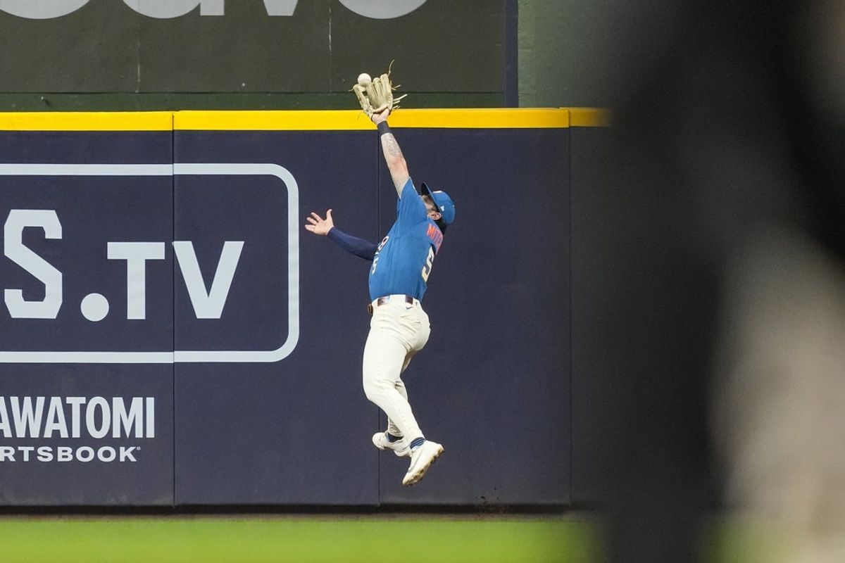 Jul 17, 2026; Milwaukee, Wisconsin, USA;  Milwaukee Brewers center fielder Garrett Mitchell (5) leaps to make a catch during the tenth inning against the Miami Marlins at American Family Field. Mandatory Credit: Jeff Hanisch-Imagn Images