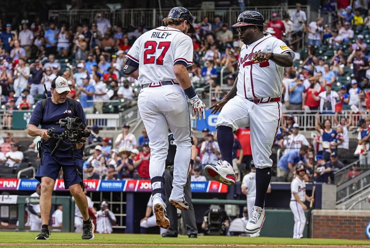 Jul 19, 2026; Cumberland, Georgia, USA; Atlanta Braves third baseman Austin Riley (27) reacts with third base coach Tommy Watkins (84) after hitting a home run against the Texas Rangers during the second inning at Truist Park. Mandatory Credit: Dale Zanine-Imagn Images