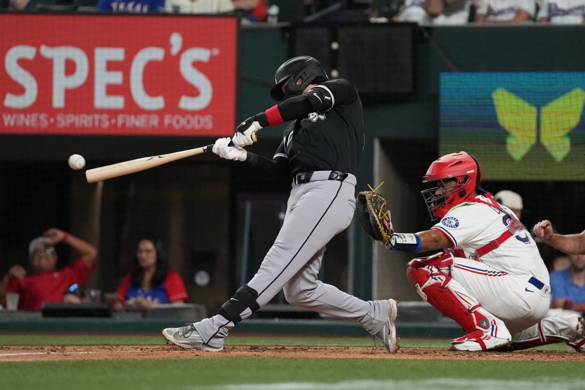 Jul 20, 2026; Arlington, Texas, USA;  Chicago White Sox third baseman Miguel Vargas (20) hits an RBI double against the Texas Rangers during the third inning at Globe Life Field. Mandatory Credit: Raymond Carlin III-Imagn Images