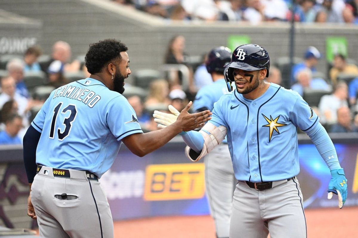 Jul 20, 2026; Toronto, Ontario, CAN;  Tampa Bay Rays right fielder Victor Mesa Jr. (25) is greeted by third baseman Junior Caminero (13) after hitting a solo home run against the Toronto Blue Jays in the second inning at Rogers Centre. Mandatory Credit: Dan Hamilton-Imagn Images