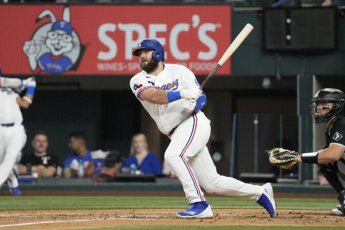 Jul 21, 2026; Arlington, Texas, USA; Texas Rangers first baseman Jake Burger (21) follows through on his RBI double against the Chicago White Sox during the third inning at Globe Life Field. Mandatory Credit: Jim Cowsert-Imagn Images