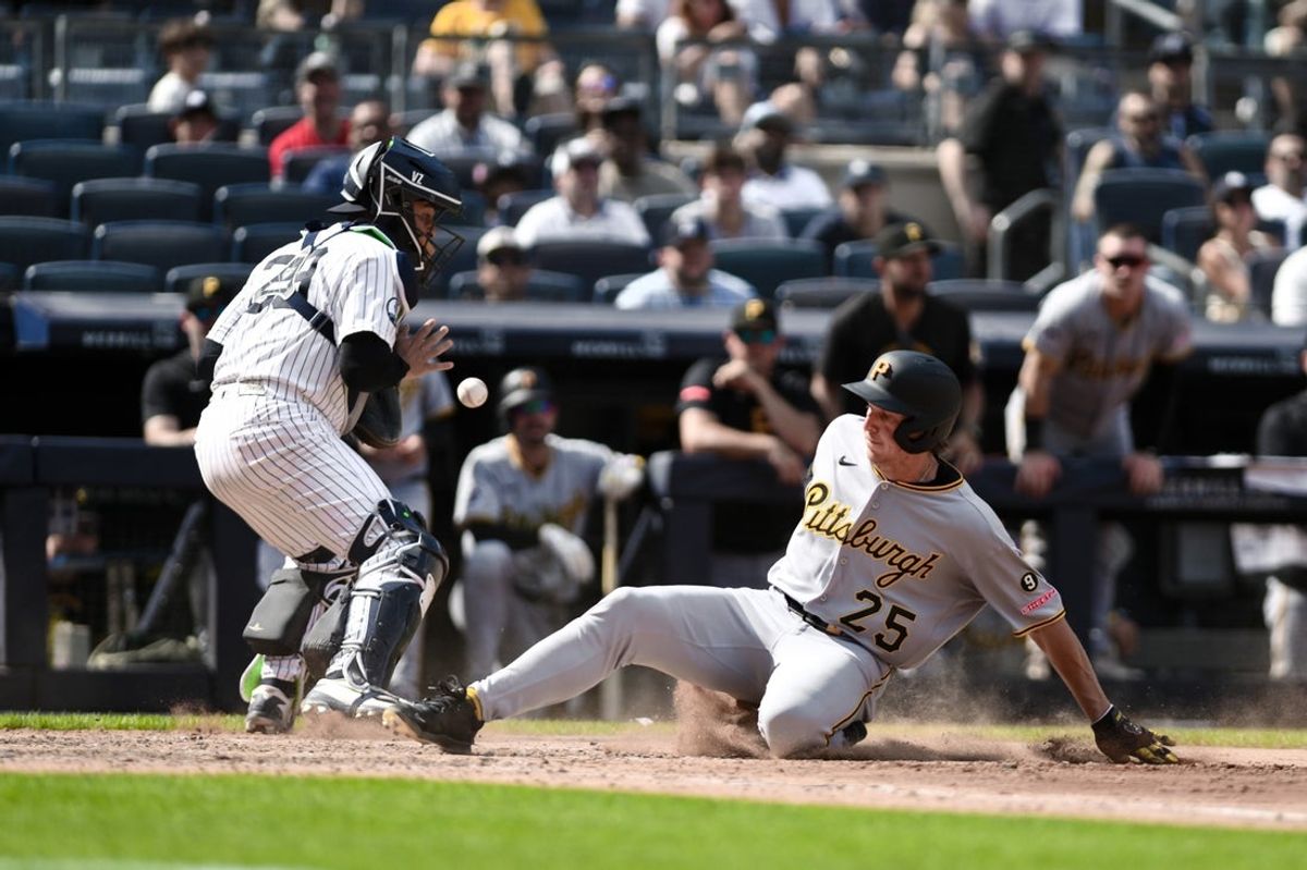 Jul 22, 2026; Bronx, New York, USA; Pittsburgh Pirates center fielder Billy Cook (25) scores on a RBI single hit by center fielder Jake Mangum (not pictured) against New York Yankees catcher Ali Sanchez (39) during the tenth inning at Yankee Stadium. Mandatory Credit: John Jones-Imagn Images