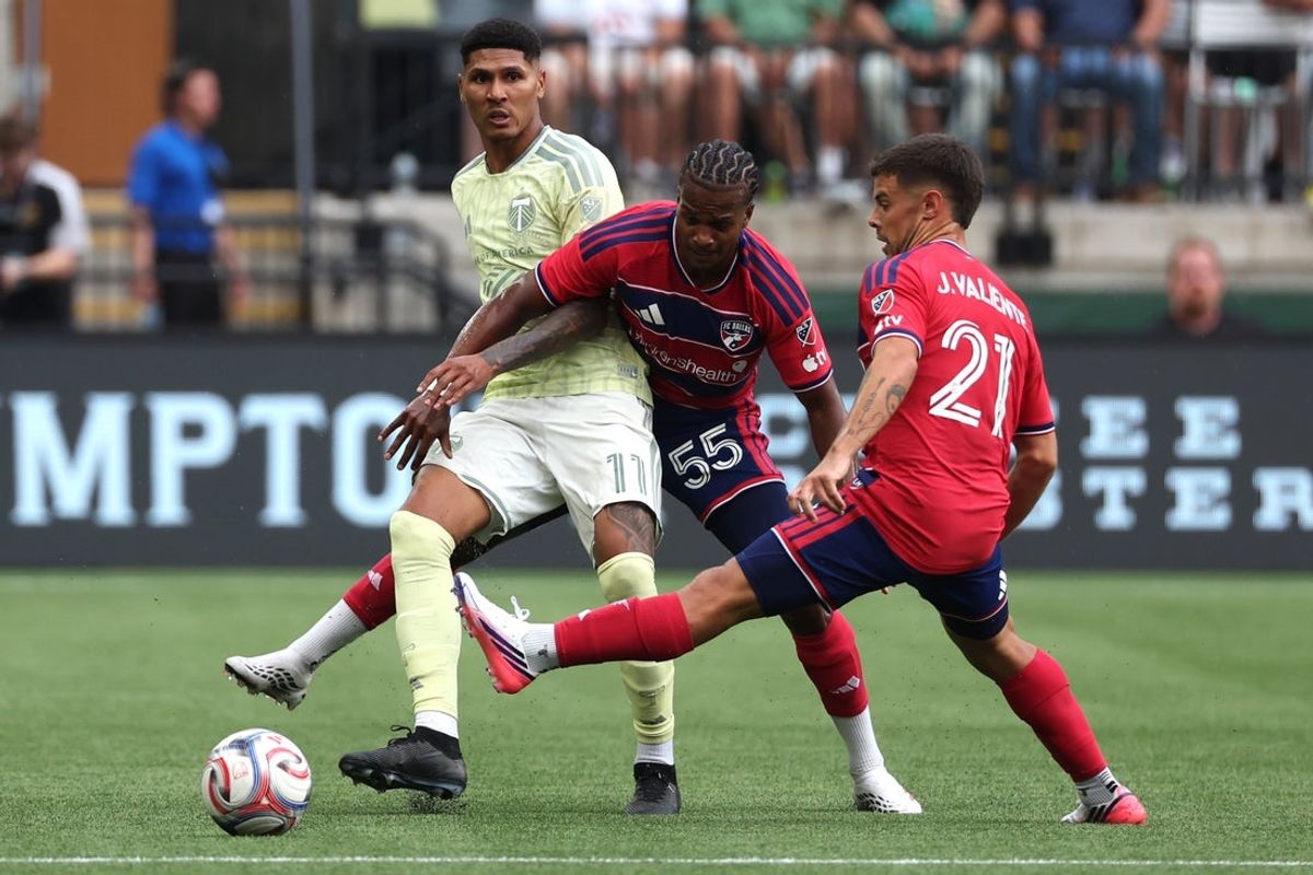 Jul 22, 2026; Portland, Oregon, USA;  Portland Timbers offense Antony Alves Santos (11) passes the ball away from FC Dallas midfield Kaick Ferreira (55) and midfield Joaquin Valiente (21) in the first half at Providence Park. Mandatory Credit: Jaime Valdez-Imagn Images