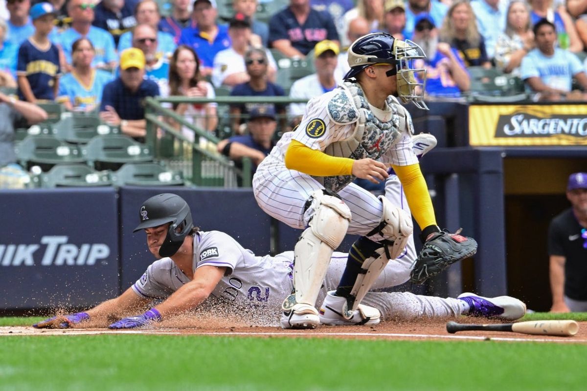 Jul 24, 2026; Milwaukee, Wisconsin, USA;  Colorado Rockies third baseman Kyle Karros (12) scores a run in the first inning before tag by Milwaukee Brewers catcher William Contreras (24) at American Family Field. Mandatory Credit: Benny Sieu-Imagn Images