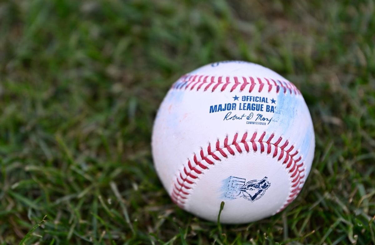 Jul 24, 2026; Boston, Massachusetts, USA; An official MLB baseball with a Toronto Blue Jays logo sits on the grass before a game against the Boston Red Sox at Fenway Park. Mandatory Credit: Eric Canha-Imagn Images