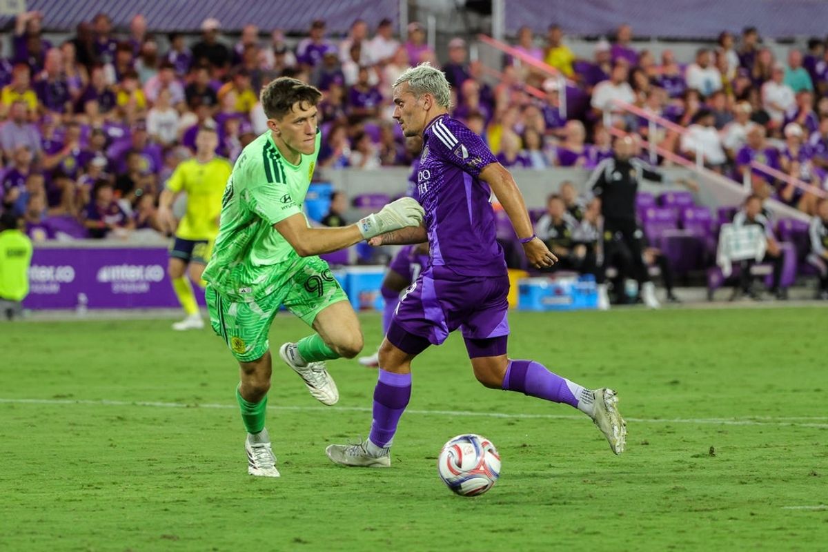 Jul 25, 2026; Orlando, Florida, USA; Orlando City SC forward Antoine Griezmann (7) runs toward the goal as Nashville SC goalkeeper Brian Schwake (99) kicks the ball during the second half at Inter.Co Stadium. Mandatory Credit: Mike Watters-Imagn Images