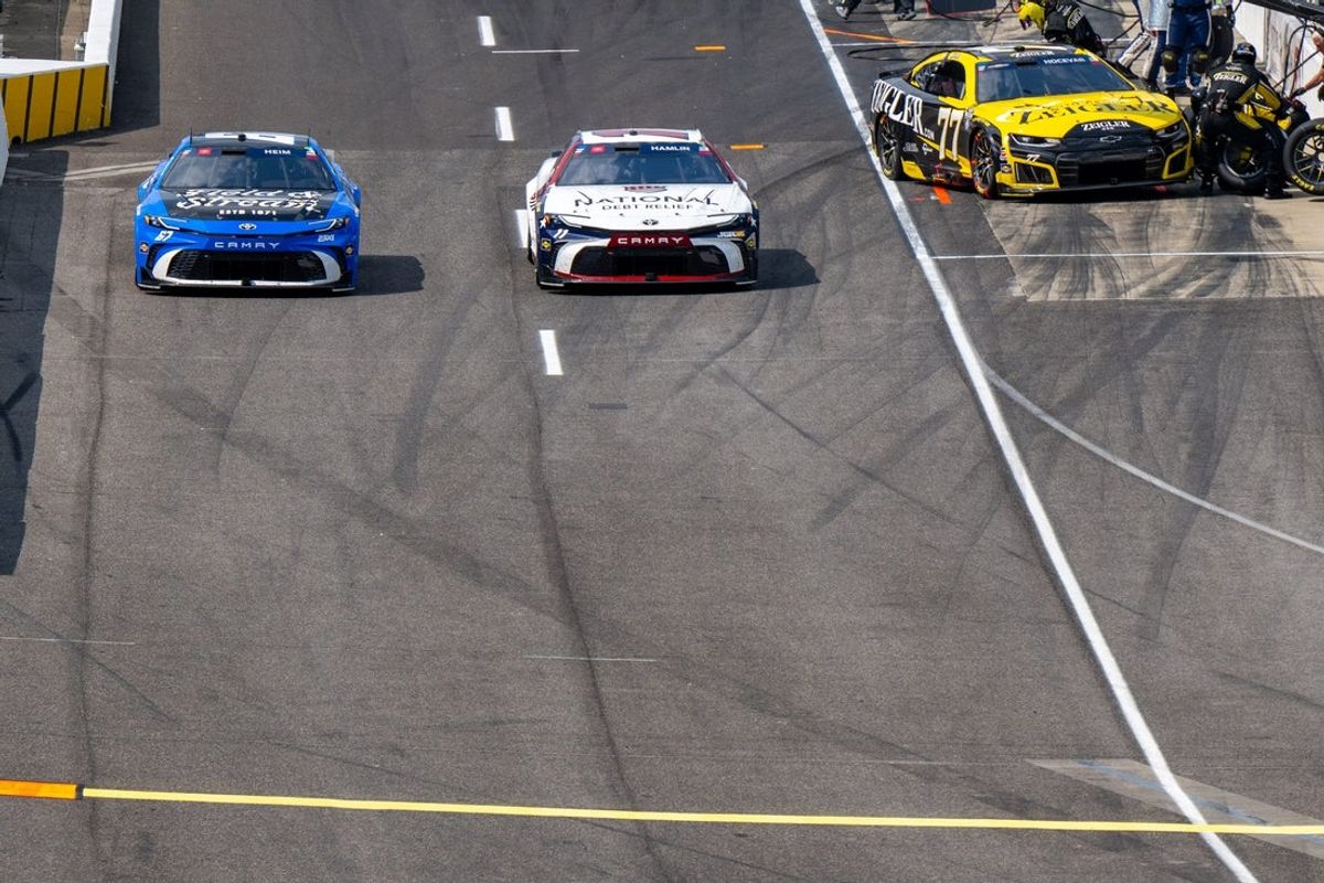 NASCAR Cup Series driver Denny Hamlin (11), right, works to stay ahead of NASCAR Cup Series driver Corey Heim (67), left, as they leave pit road Sunday, July 26, 2026 during the NASCAR Brickyard 400 at Indianapolis Motor Speedway in Speedway, Ind.