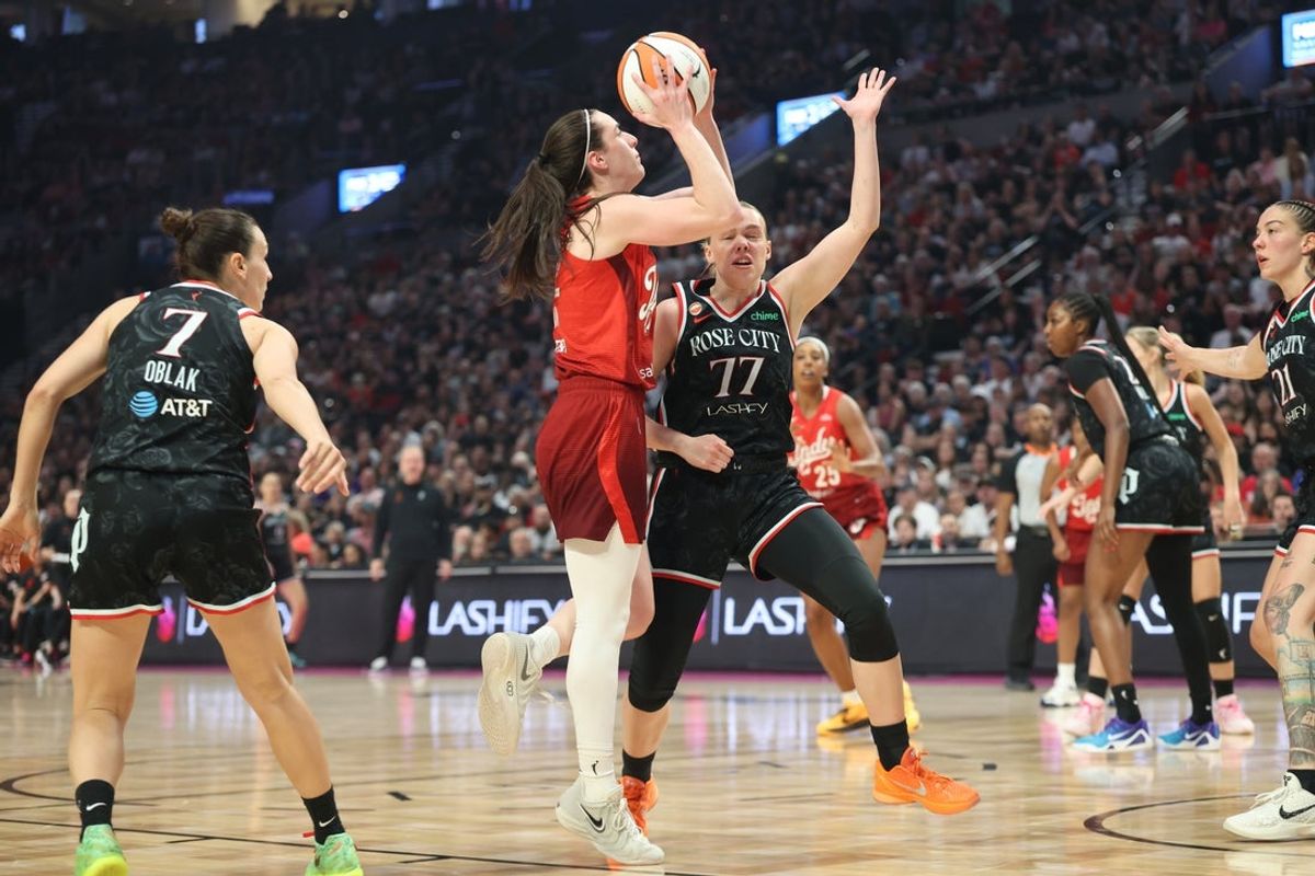 Jul 31, 2026; Portland, Oregon, USA;  Indiana Fever guard Caitlin Clark (22) shoots the ball against Portland Fire guard Holly Winterburn (77) during the first half at Moda Center. Mandatory Credit: Jaime Valdez-Imagn Images