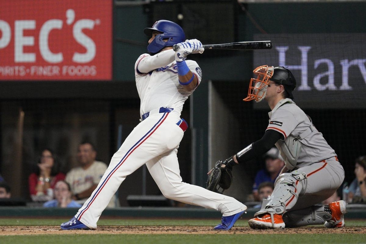 Aug 4, 2026; Arlington, Texas, USA;  Texas Rangers shortstop Ezequiel Duran (20) hits a walk-off RBI double against the San Francisco Giants during the ninth inning at Globe Life Field. Mandatory Credit: Raymond Carlin III-Imagn Images