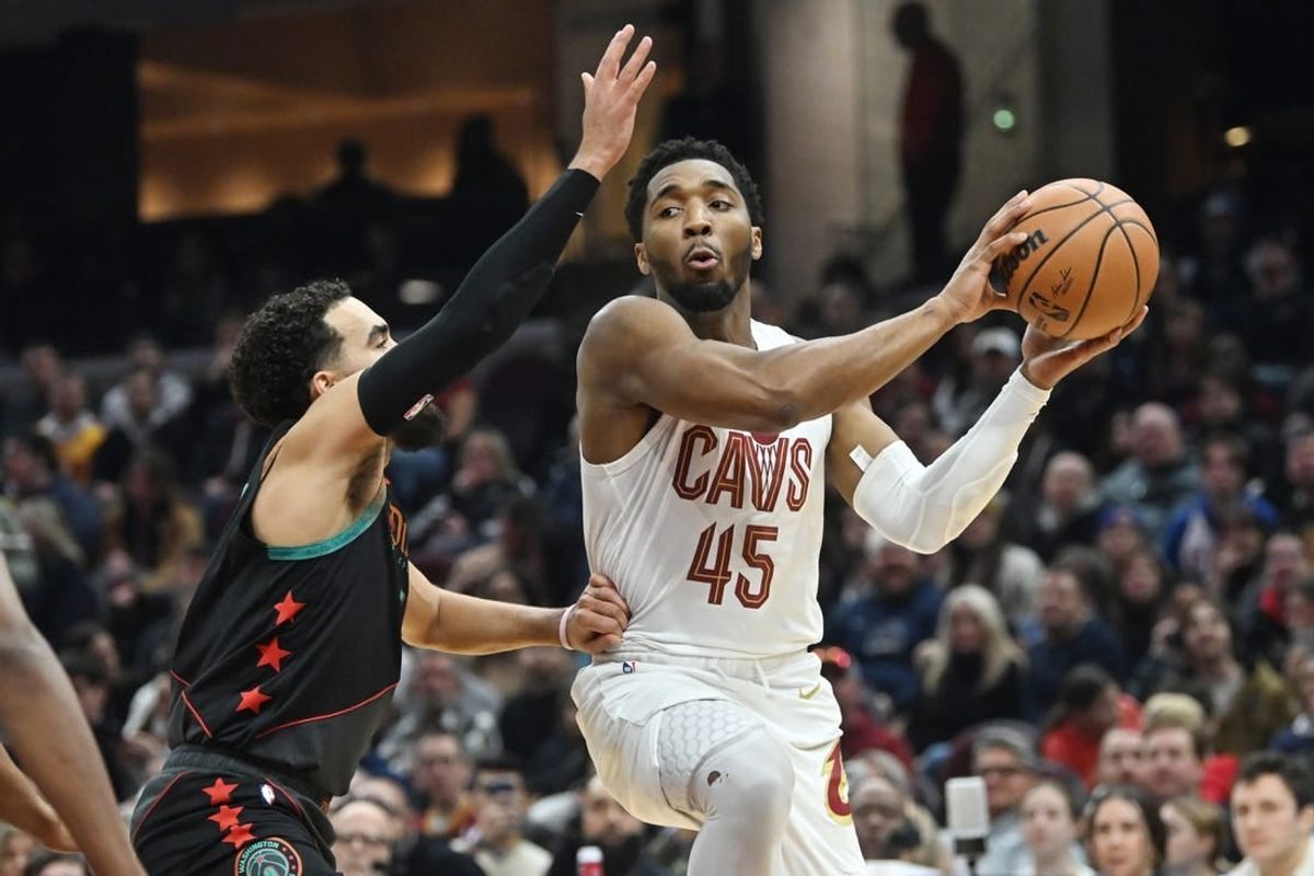 Jan 5, 2024; Cleveland, Ohio, USA; Cleveland Cavaliers guard Donovan Mitchell (45) drives to the basket against Washington Wizards guard Tyus Jones (5) during the first half at Rocket Mortgage FieldHouse.