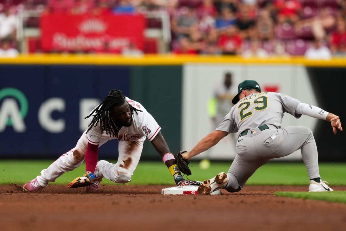 Aug 5, 2026; Cincinnati, Ohio, USA;  Cincinnati Reds shortstop Elly de la Cruz, left, steals second base ahead of the tag from Athletics' second baseman Donovan Walton, right, in the third inning at Great American Ball Park. Mandatory Credit: Aaron Doster-Imagn Images