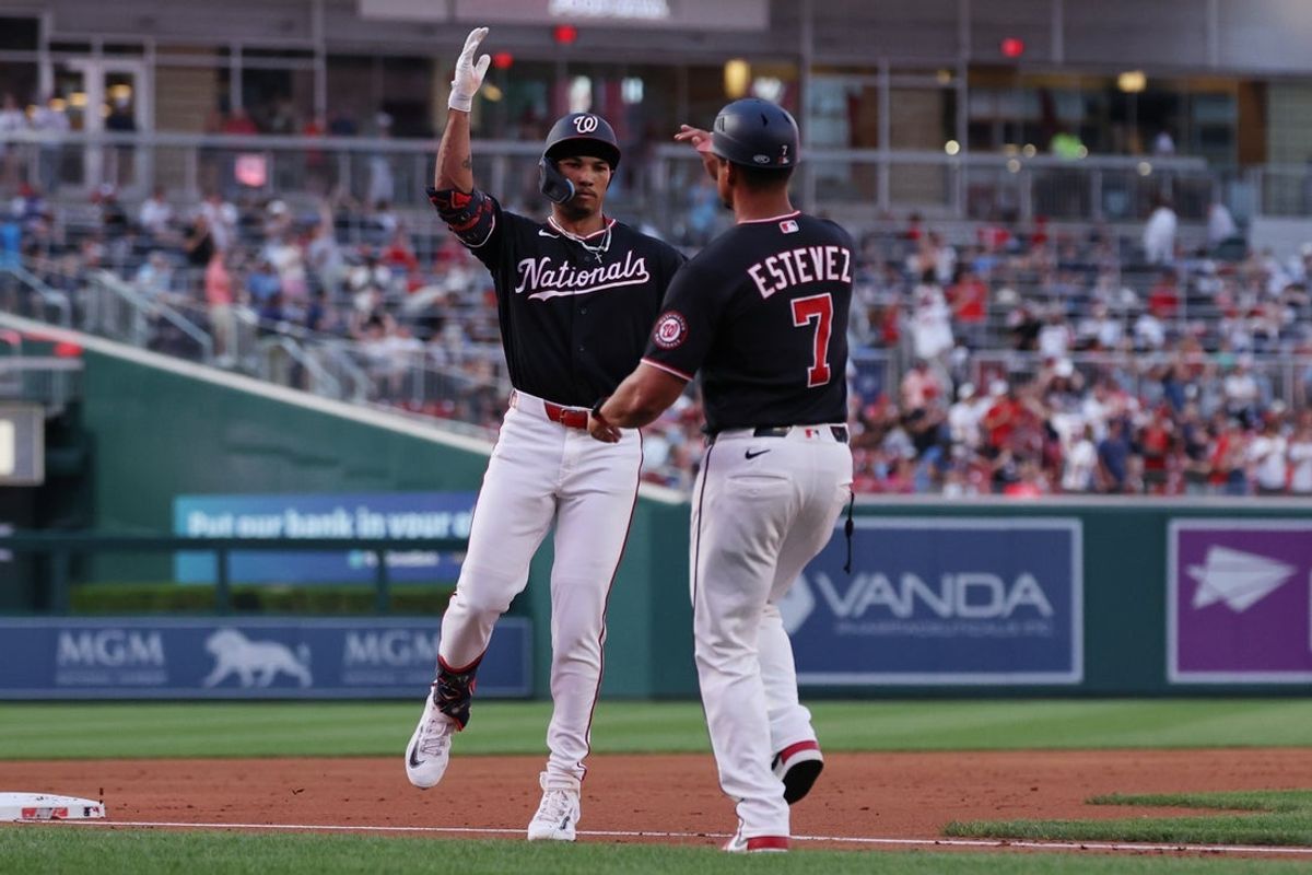Aug 7, 2026; Washington, District of Columbia, USA; Washington Nationals left fielder Daylen Lile (4) celebrates with Nationals third base coach Victor Estevez (7) while rounding the bases after hitting a three run home run against the Cincinnati Reds during the first inning at Nationals Park. Mandatory Credit: Geoff Burke-Imagn Images