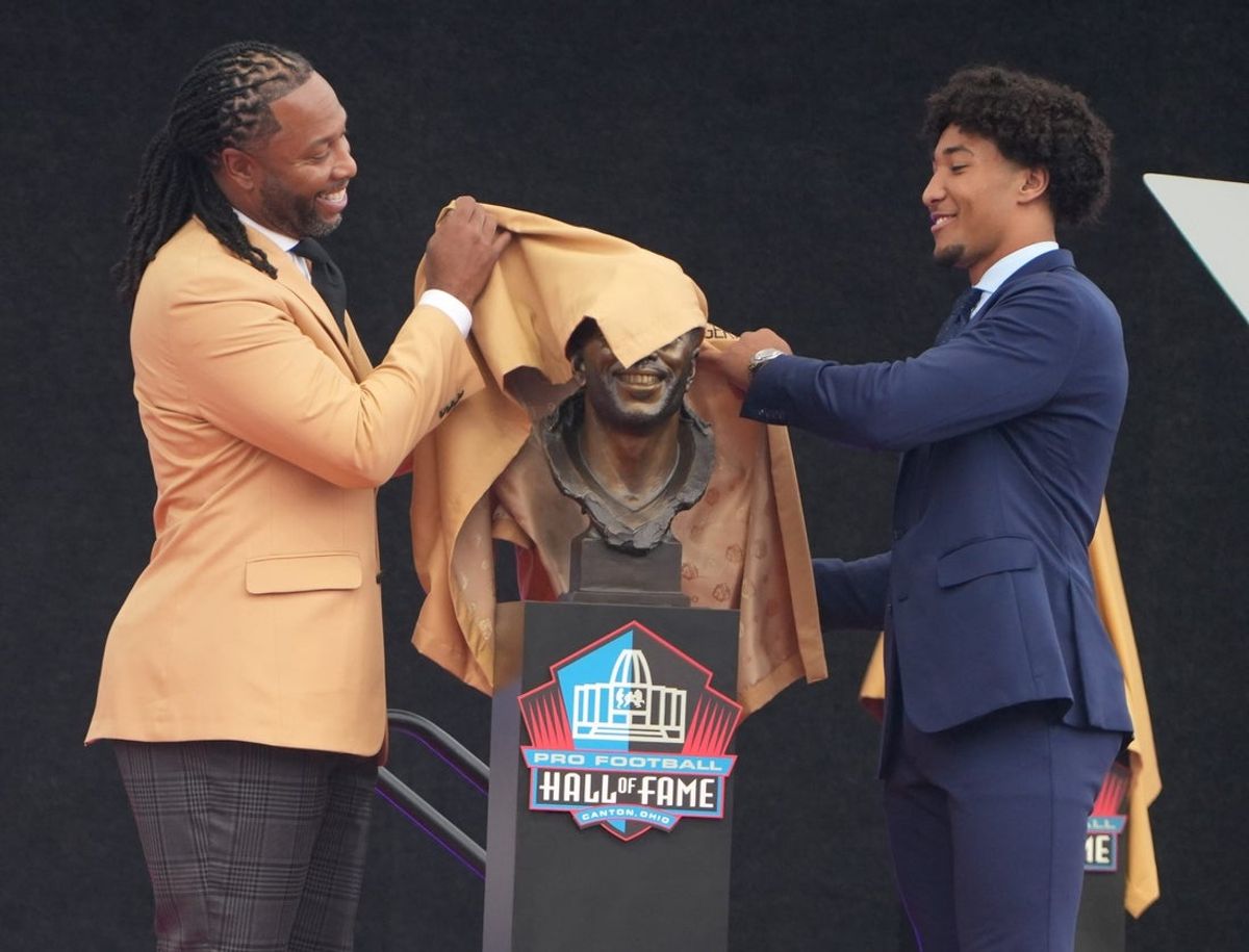 Pro Football Hall of Fame enshrinee Larry Fitzgerald and his son Devin Fitzgerald unveil his bust during the Class of 2026 enshrinement ceremony at Tom Benson Hall of Fame Stadium in Canton, Ohio, on Aug. 8, 2026.