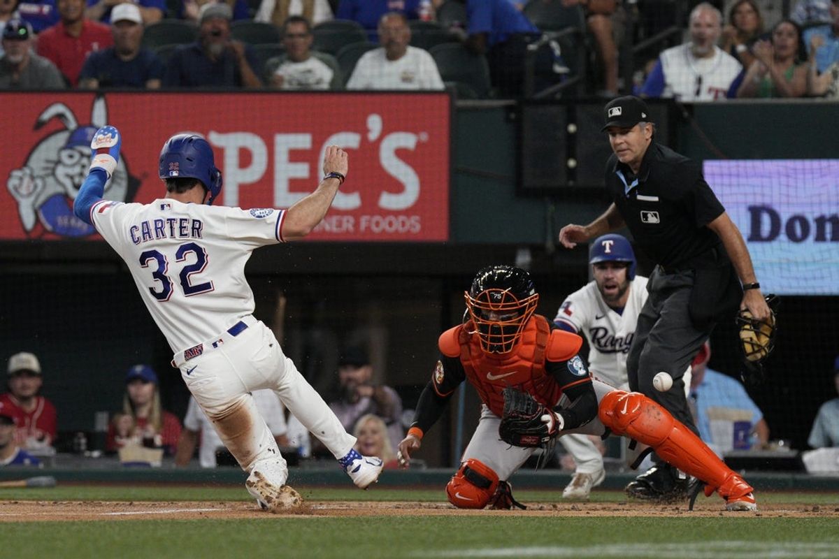Aug 8, 2026; Arlington, Texas, USA;  Texas Rangers center fielder Evan Carter (32) slides into home plate to score a run as Baltimore Orioles catcher Carlos Narvaez (75) cannot handle the throw during the second inning at Globe Life Field. Mandatory Credit: Raymond Carlin III-Imagn Images