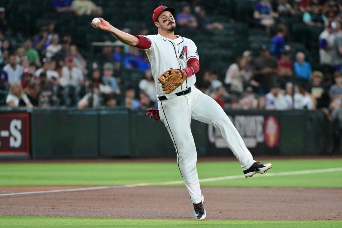 Aug 12, 2026; Phoenix, Arizona, USA; Arizona Diamondbacks third baseman Nolan Arenado (28) fields a ground ball and throws to first base for an out in the first inning against the Colorado Rockies at Chase Field. Mandatory Credit: Matt Kartozian-Imagn Images