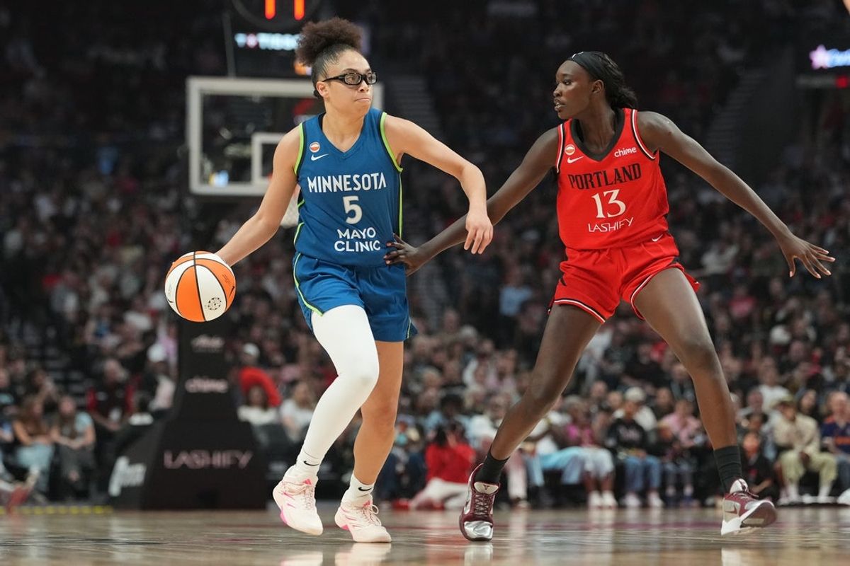 Aug 12, 2026; Portland, Oregon, USA; Minnesota Lynx guard Olivia Miles (5) handles the ball against Portland Fire forward Nyadiew Puoch (13) during the first half at Moda Center. Mandatory Credit: Soobum Im-Imagn Images