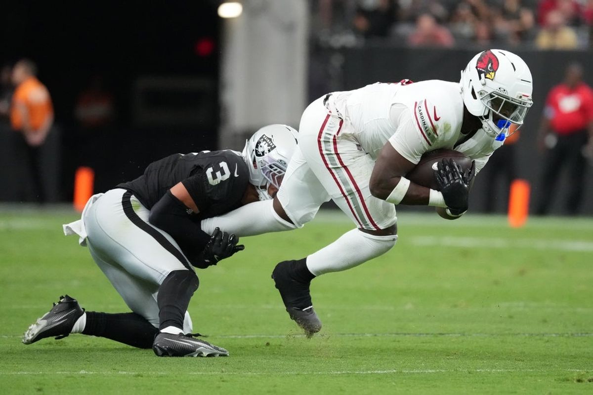 Aug 13, 2026; Paradise, Nevada, USA; Arizona Cardinals running back Jeremiyah Love (4) carries the ball against Las Vegas Raiders cornerback Taron Johnson (3) in the first half at Allegiant Stadium. Mandatory Credit: Kirby Lee-Imagn Images