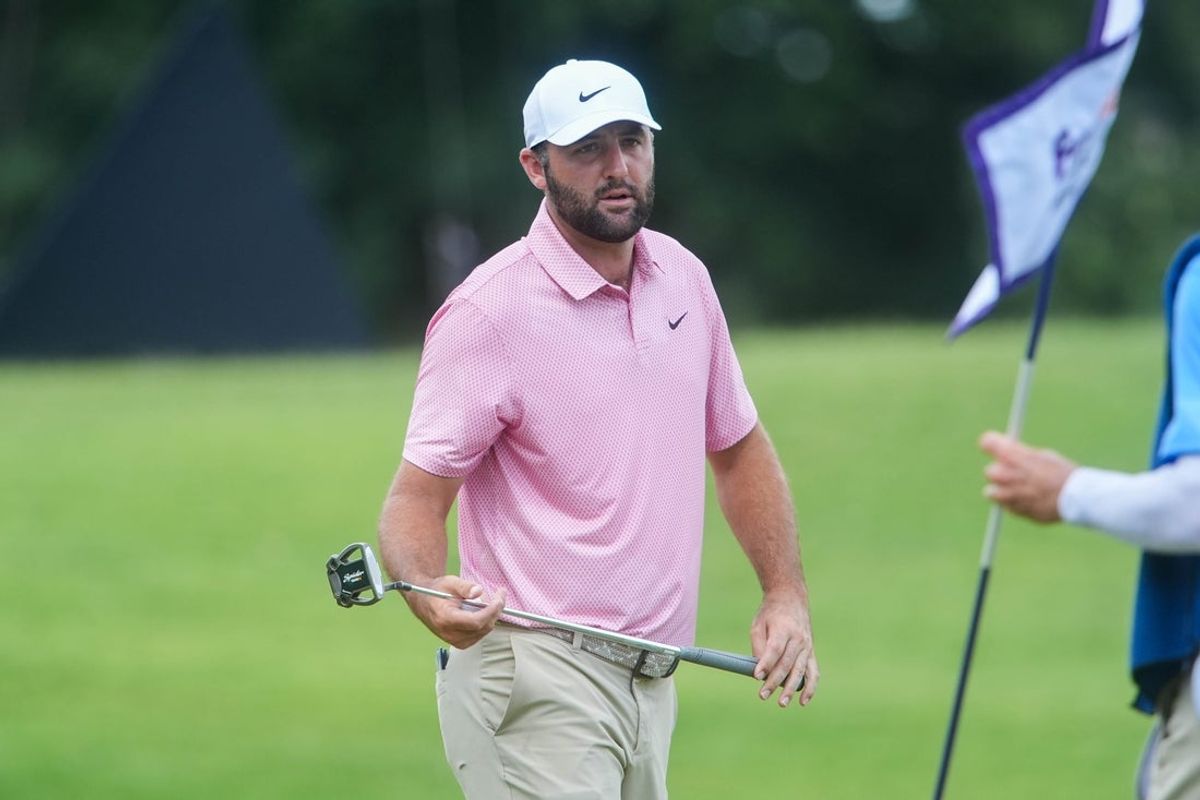 Scottie Scheffler hands his putter to his caddie on the seventh hole during the second round of the FedEx St. Jude Championship at TPC Southwind in Memphis, Tenn., on August 14, 2026.