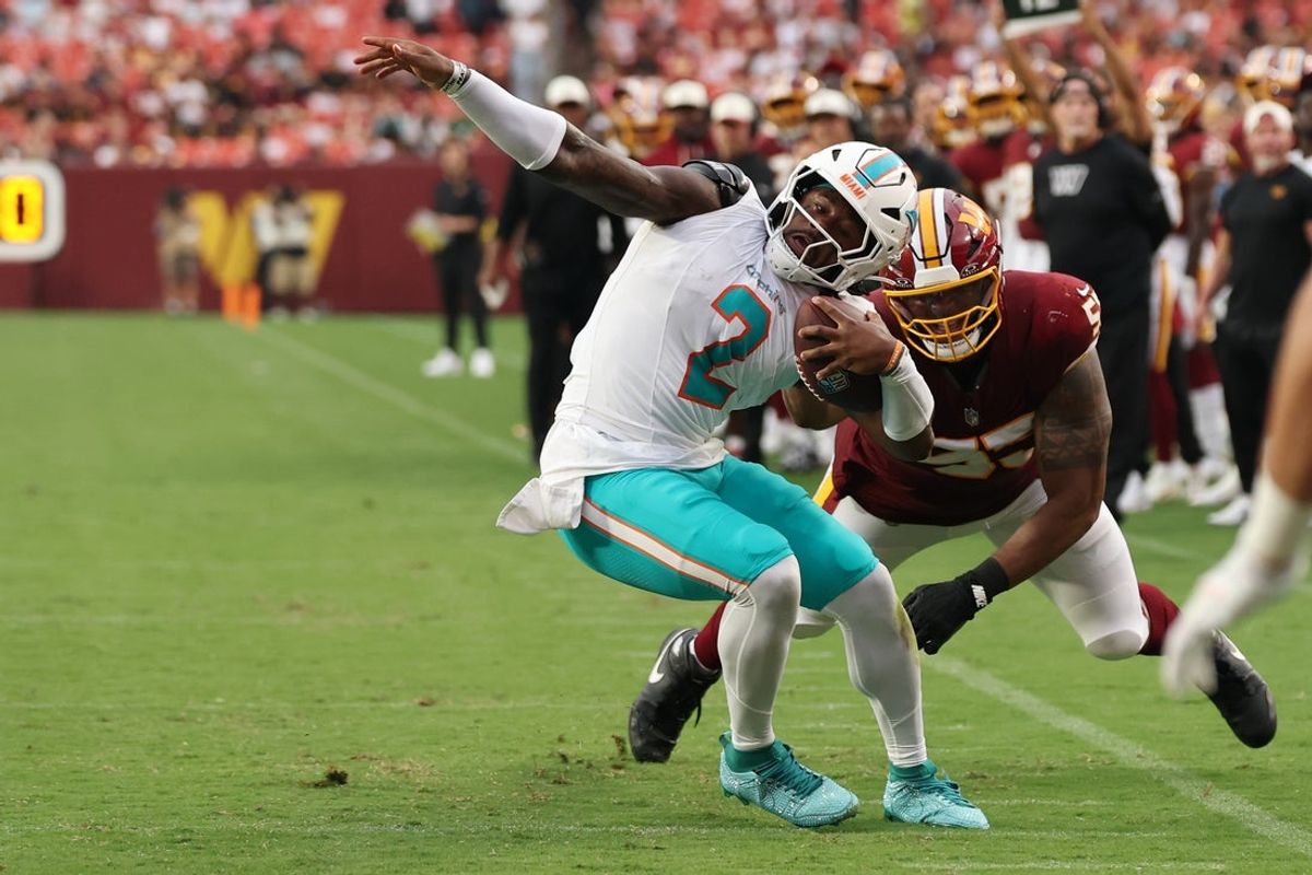 Aug 14, 2026; Landover, Maryland, USA; Miami Dolphins quarterback Malik Willis (2) is horse collar tackled by Washington Commanders defensive tackle Byron Cowart (55) during the first half at Northwest Stadium. Mandatory Credit: Geoff Burke-Imagn Images
