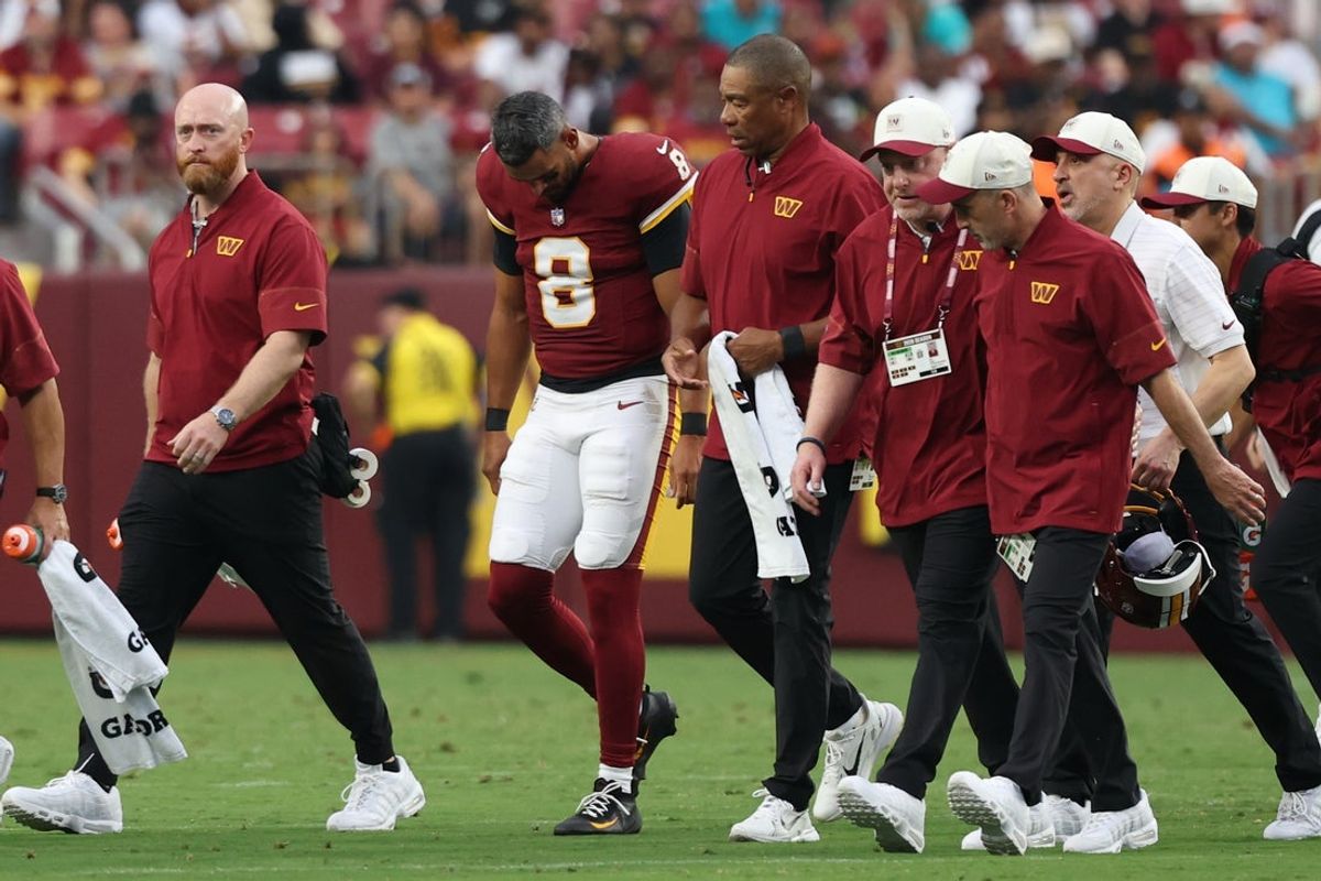 Aug 14, 2026; Landover, Maryland, USA; Washington Commanders quarterback Marcus Mariota (8) is escorted off the field by Commanders medical staff after being injured against the Miami Dolphins during the first half at Northwest Stadium. Mandatory Credit: Geoff Burke-Imagn Images