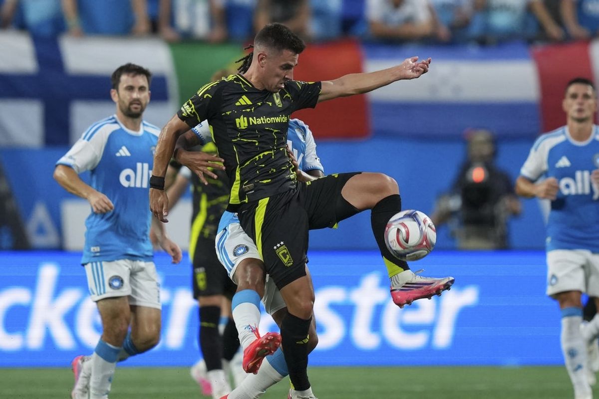 Aug 15, 2026; Charlotte, North Carolina, USA; Columbus Crew defense Brooks Lennon (11) gets the stop on the ball over Charlotte FC offense Idan Toklomati (9) during the first half at Bank of America Stadium. Mandatory Credit: Jim Dedmon-Imagn Images