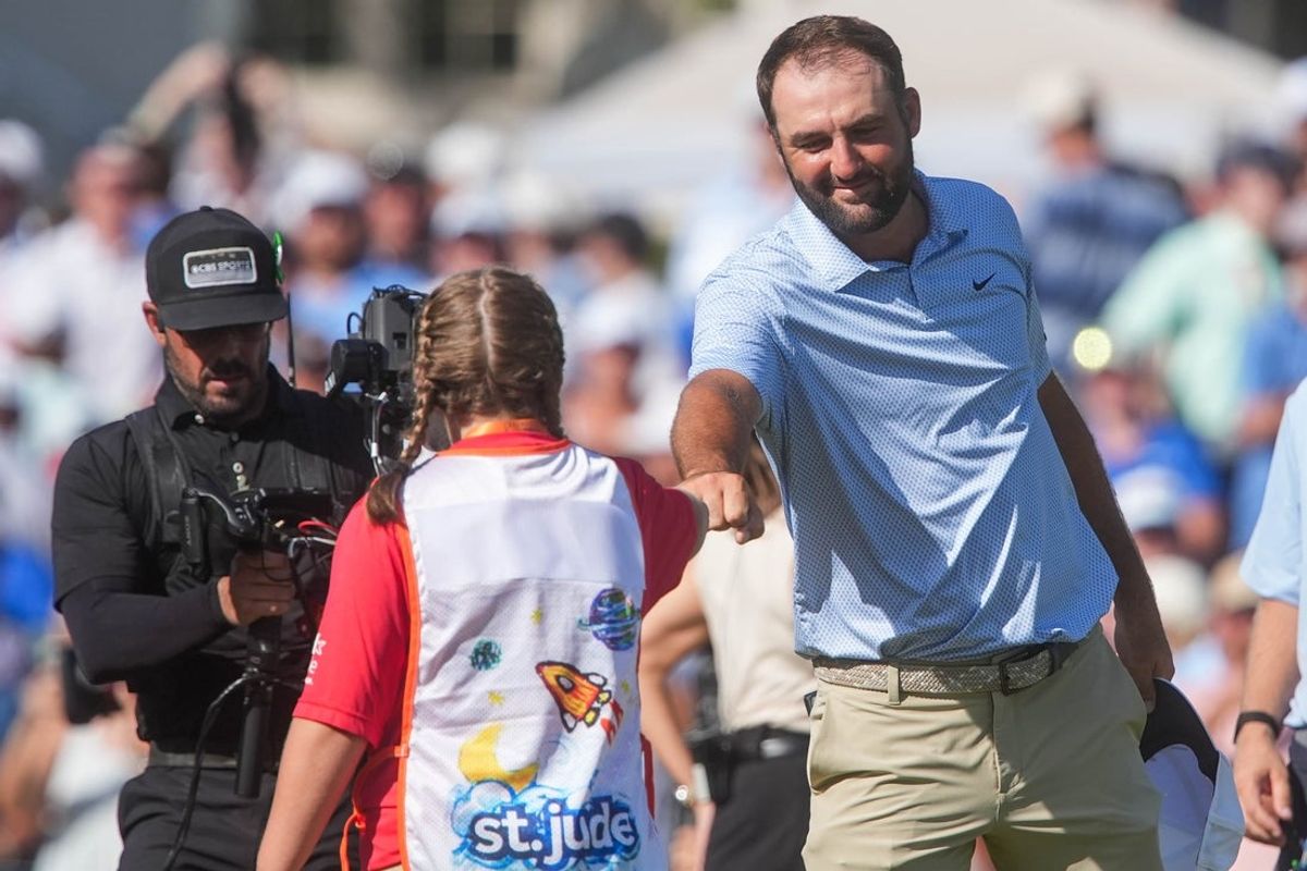Scottie Scheffler fist bumps a St. Jude Children's Hospital patient who was the flag holder on the 18th hole after Scheffler won the FedEx St. Jude Championship with an eight stroke lead at TPC Southwind in Memphis, Tenn., on August 16, 2026.