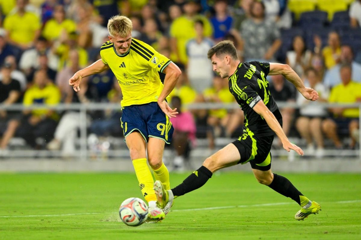 Aug 22, 2026; Nashville, Tennessee, USA;  Columbus Crew midfield Sean Zawadzki (25) plays the ball against Nashville SC forward Sam Surridge (9) during the first half at Geodis Park.  Mandatory Credit: Steve Roberts-Imagn Images