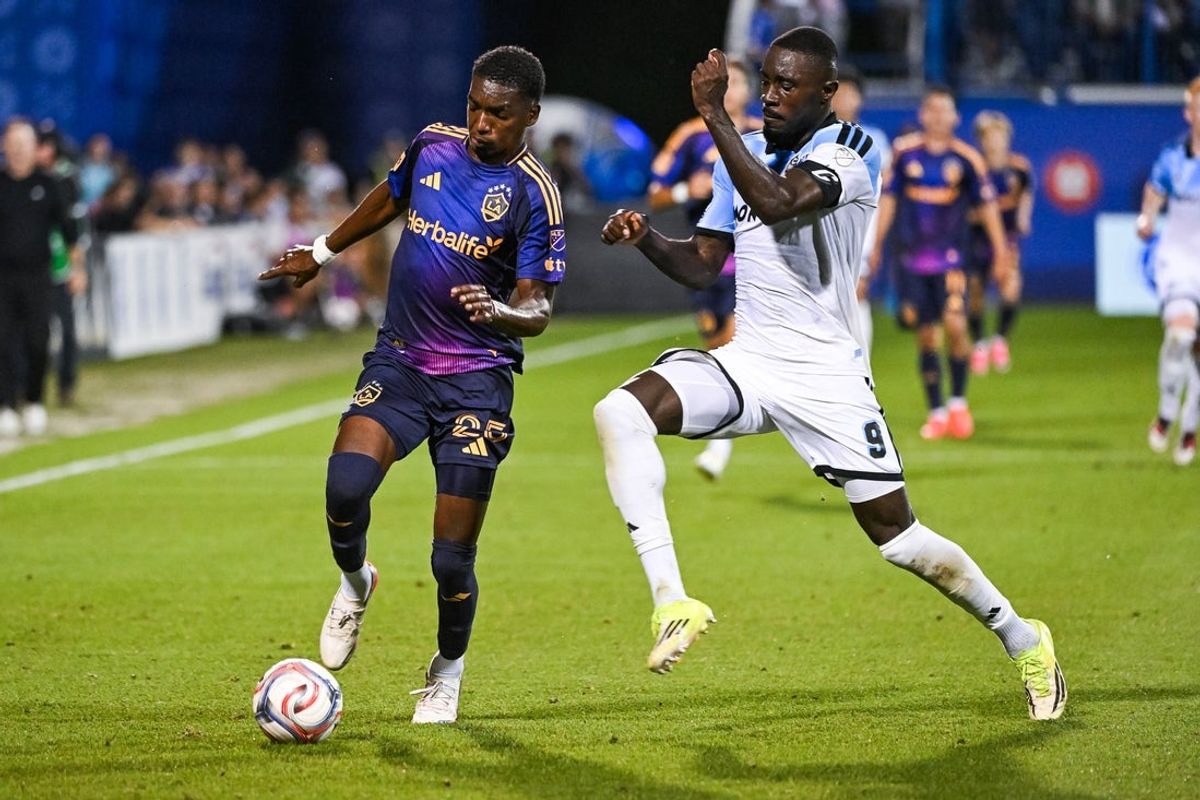 Aug 22, 2026; Montreal, Province of Quebec, CAN;  LA Galaxy defender Carlos Garces (25) defends the ball against CF Montreal forward Prince Owusu (9) during the second half at Saputo Stadium.  Mandatory Credit: David Kirouac-Imagn Images