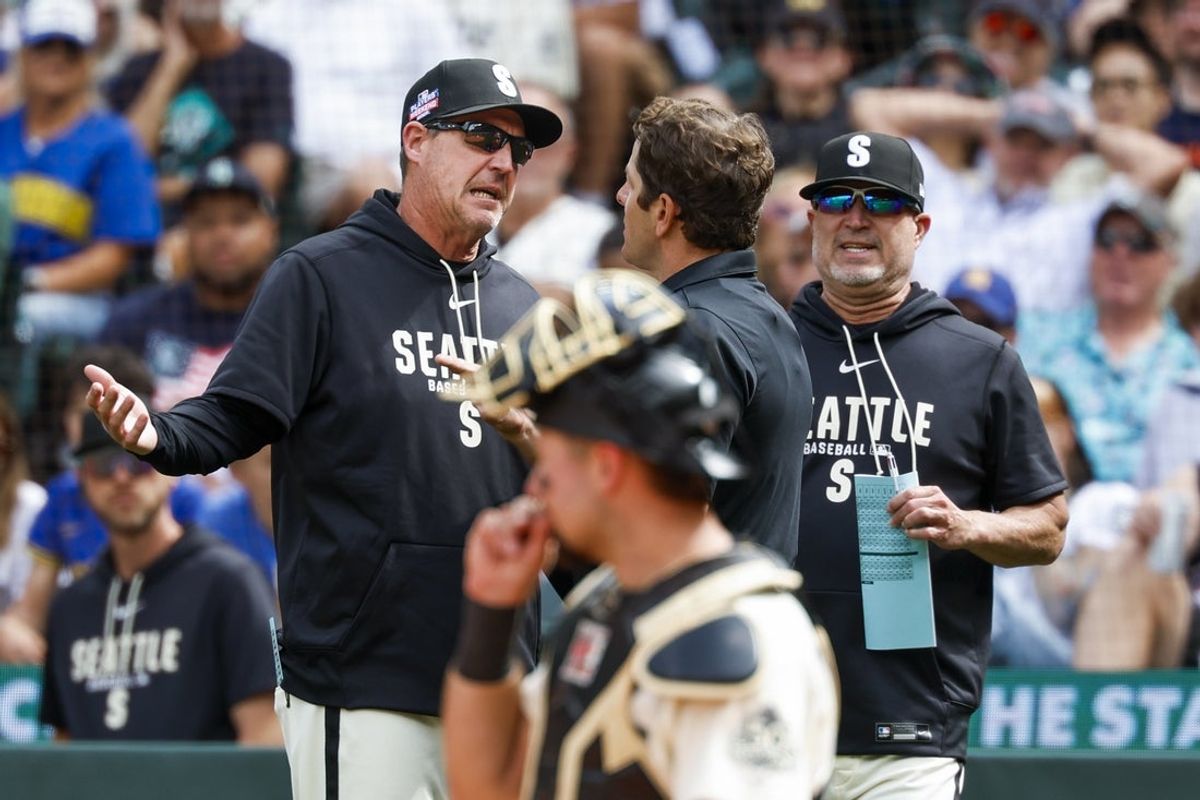 Aug 23, 2026; Seattle, Washington, USA; Seattle Mariners manager Dan Wilson (6) speaks with umpire Ben May (97) during the sixth inning at T-Mobile Park. Mandatory Credit: Joe Nicholson-Imagn Images