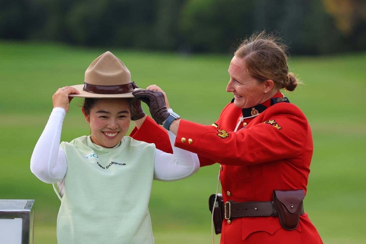 Aug 23, 2026; Edmonton, Alberta, CAN;  Miyu Yamashita tries on the hat of an RCMP member after her win of the CPKC Women's Open at Royal Mayfair Golf Club.  Mandatory Credit: James Maclennan-Imagn Images