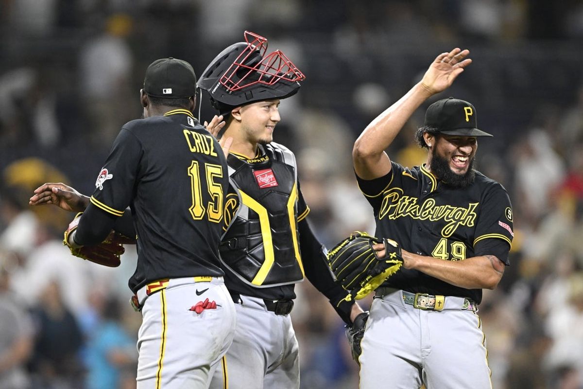 Aug 24, 2026; San Diego, California, USA;  Pittsburgh Pirates center fielder Oneil Cruz (15), catcher Rafael Flores Jr. (43) and pitcher Yohan Ramirez (49) celebrate after the Pirates beat the San Diego Padres at Petco Park.  Mandatory Credit: Denis Poroy-Imagn Images