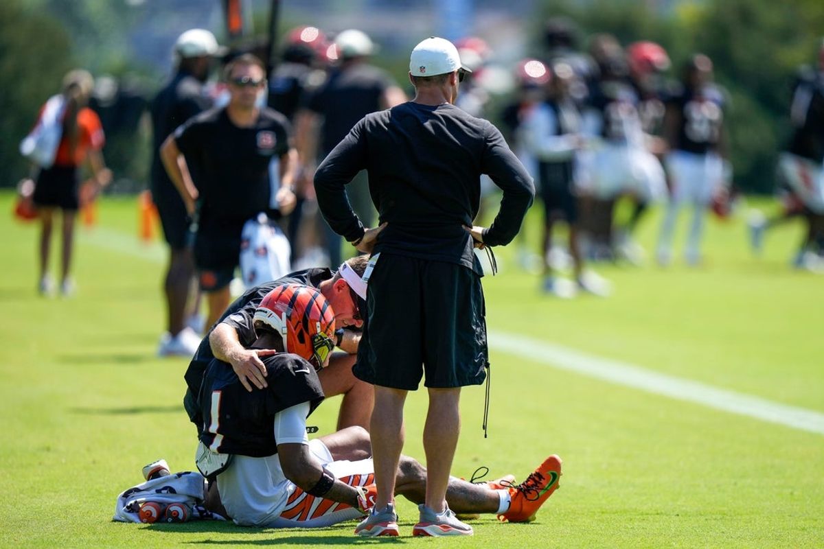 Cincinnati Bengals wide receiver Ja'marr Chase (1) takes a seat as he’s examined by the training staff after a collision with cornerback DJ Turner II (0) during Bengals training camp practice at the Paycor Stadium practice facility in downtown Cincinnati on Tuesday, Aug. 25, 2026.