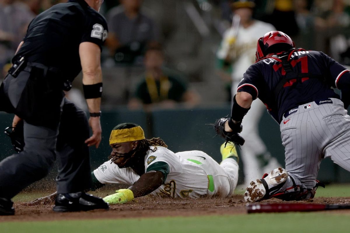 Aug 25, 2026; West Sacramento, California, USA;  Athletics right fielder Lawrence Butler (4) slides ahead of the tag of Minnesota Twins catcher Victor Caratini (37) during the sixth inning at Sutter Health Park.  Mandatory Credit: Dennis Lee-Imagn Images