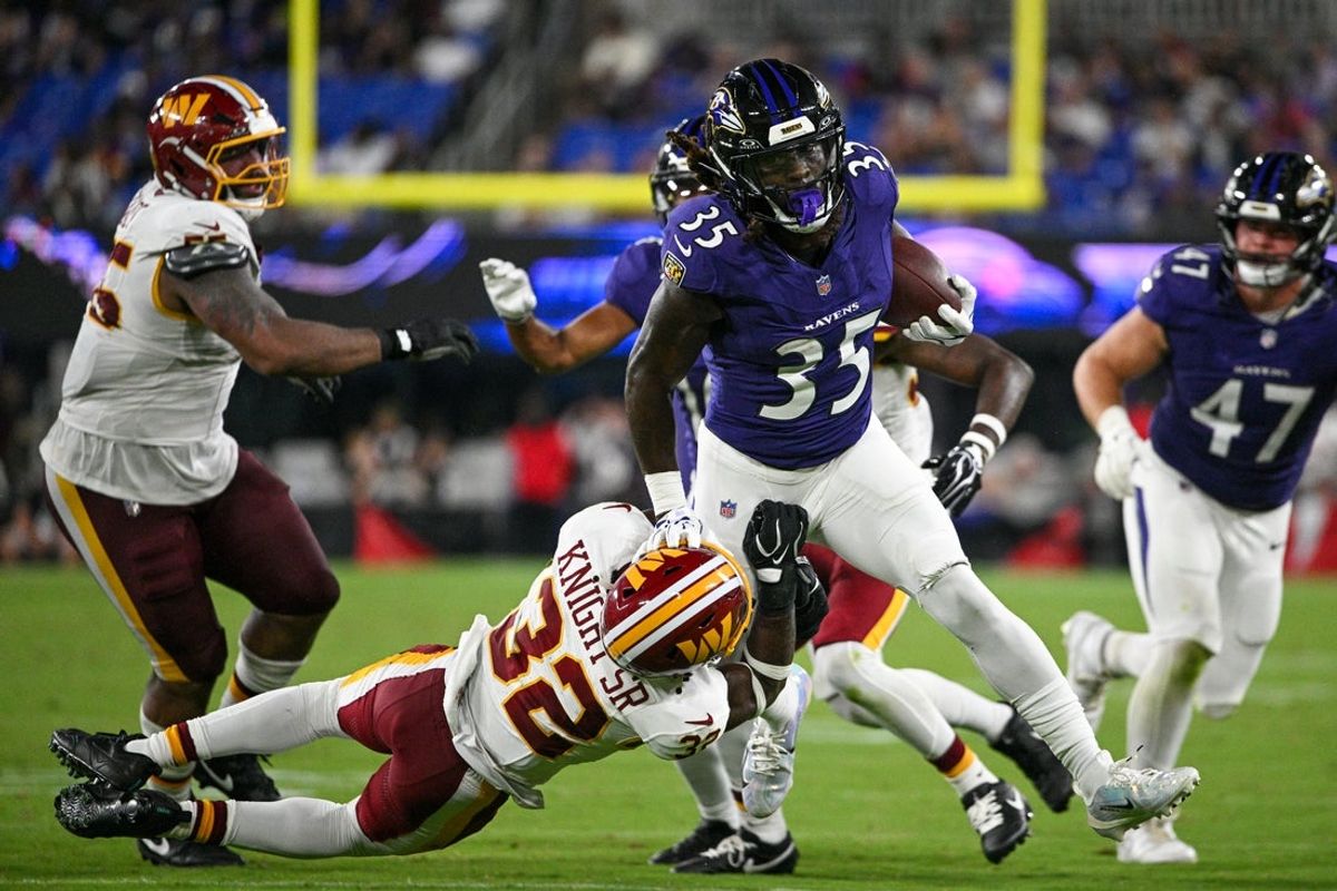 Aug 28, 2026; Baltimore, Maryland, USA;  Baltimore Ravens running back Jonathan Ward (35) runs through Washington Commanders safety Qwuantrezz Knight (32) tackle attempt during the second half at M&T Bank Stadium. Mandatory Credit: Tommy Gilligan-Imagn Images