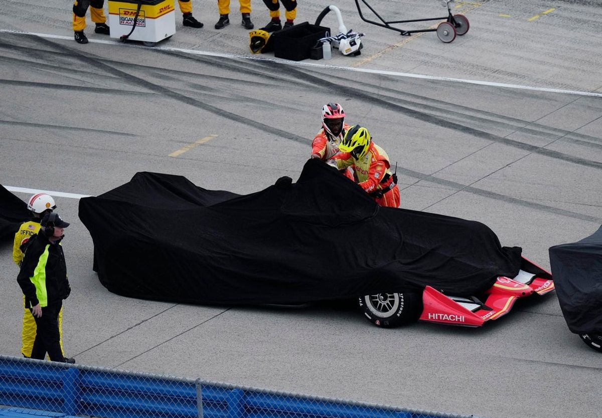 Crew members cover David Malukas of Team Penske (12) car in the pit road for a rain delay during the NTT IndyCar Series Snap-on Makers and Fixers 250 at the Milwaukee Mile in West Allis, Wisconsin on Aug. 29, 2026.