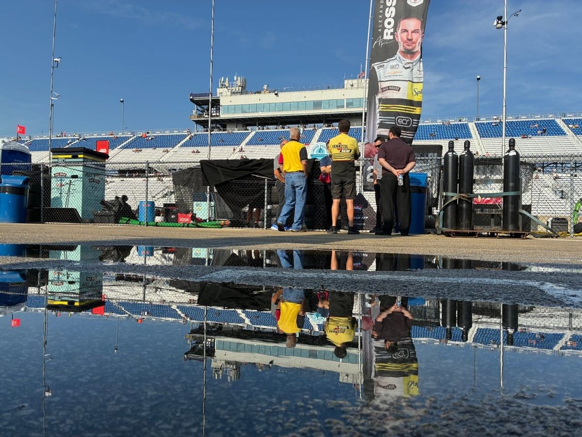 Fans talk along pit road as work continues to dry the track for the NTT IndyCar Series Snap-on Makers and Fixers 250 on Aug. 30, 2026, at the Milwaukee Mile in West Allis, Wisconsin.