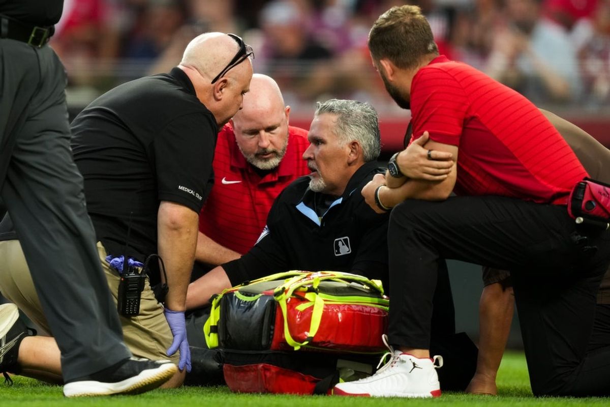 Aug 31, 2026; Cincinnati, Ohio, USA;  Umpire Manny Gonzalez (79) is tended to on the field during the game between the San Diego Padres and the Cincinnati Reds at Great American Ball Park. Mandatory Credit: Aaron Doster-Imagn Images