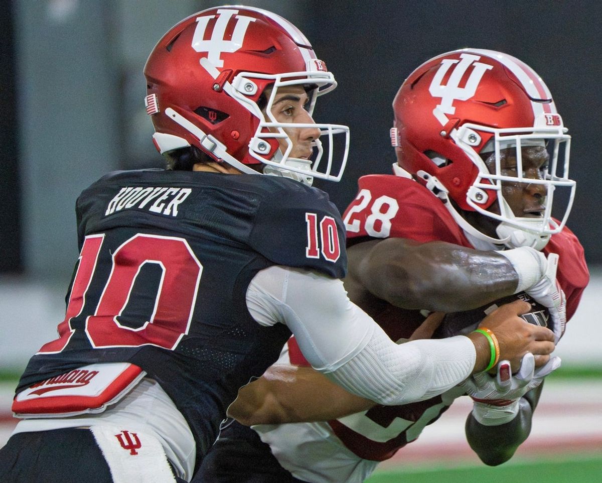 Indiana's Josh Hoover (10) hands off to Khobie Martin (28) during Indiana University's football camp practice on Wednesday, Aug. 19, 2026.