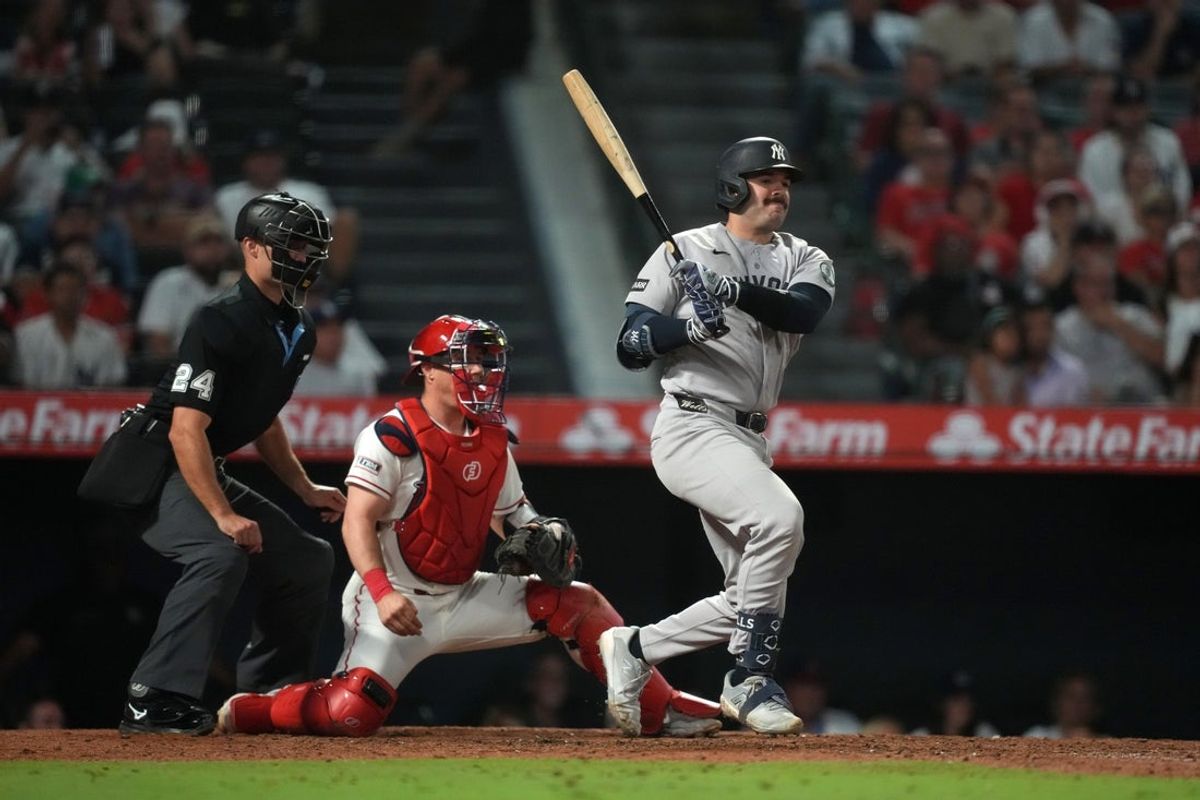 Sep 2, 2026; Anaheim, California, USA; New York Yankees catcher Austin Wells (28) hits a two RBI single in the 10th inning as Los Angeles Angels designated hitter Moisés Ballesteros (13) and home plate umpire Dillon Wilson at Angel Stadium. Mandatory Credit: Kirby Lee-Imagn Images